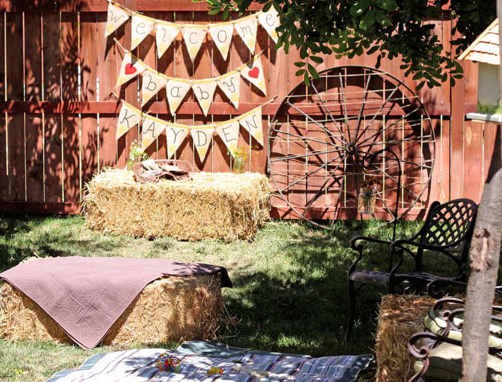 homemade burlap banner, old wagon wheel and hay bales offered a ...